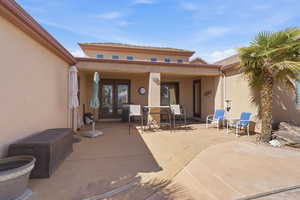 Rear view of property featuring a patio area, stucco siding, and french doors