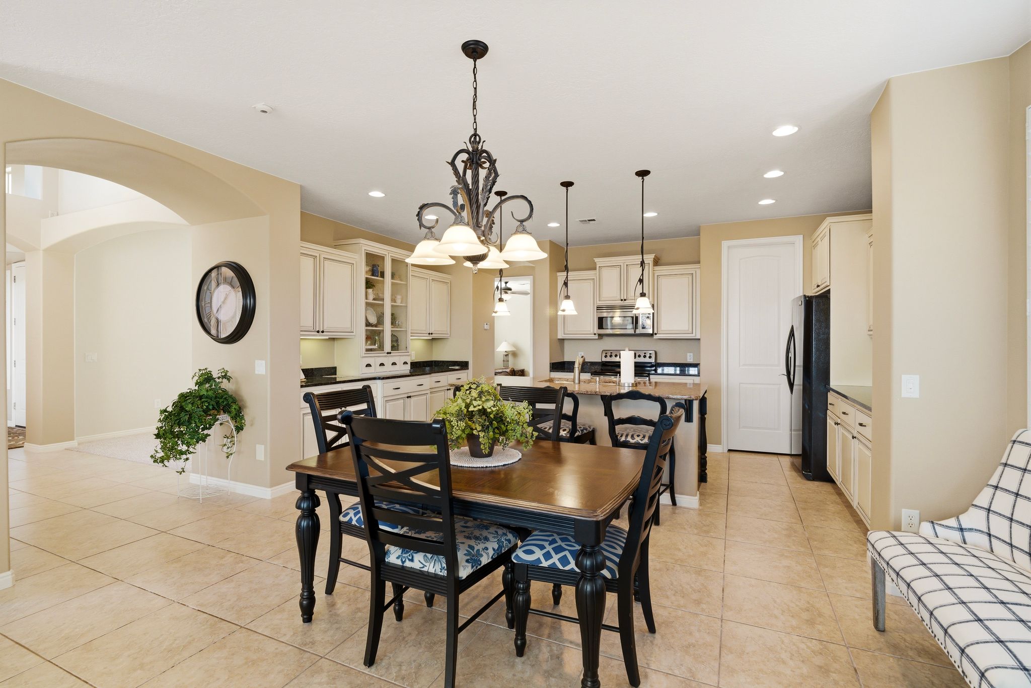 Dining space with arched walkways, light tile patterned floors, and suspended lighting