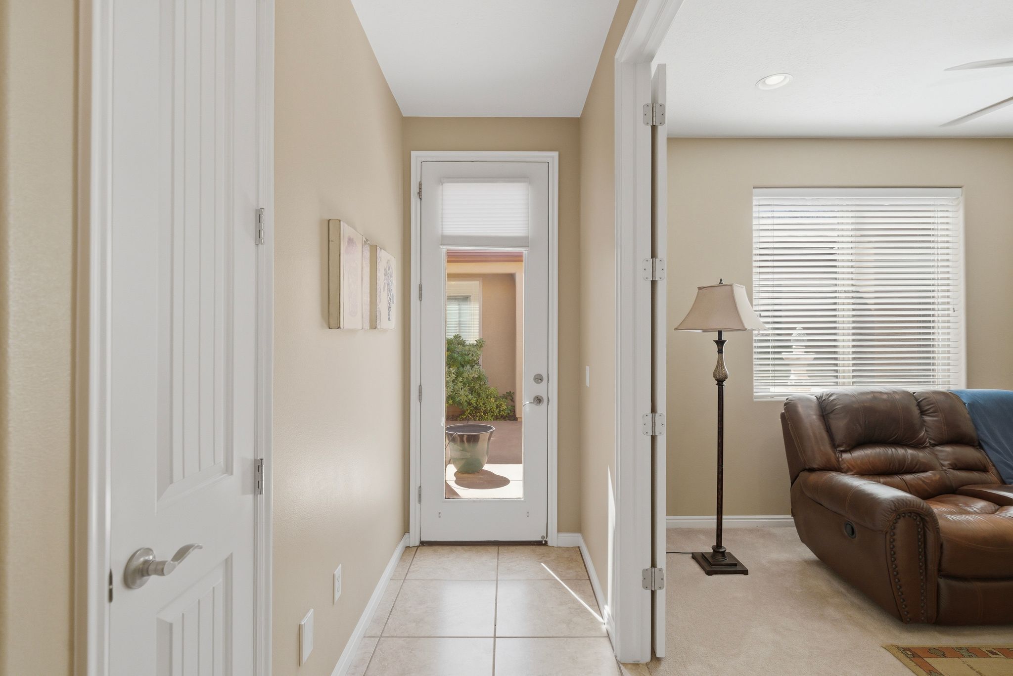 Hall with light tile patterned flooring and light colored carpet