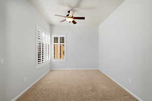 Spare room featuring a ceiling fan and light colored carpet