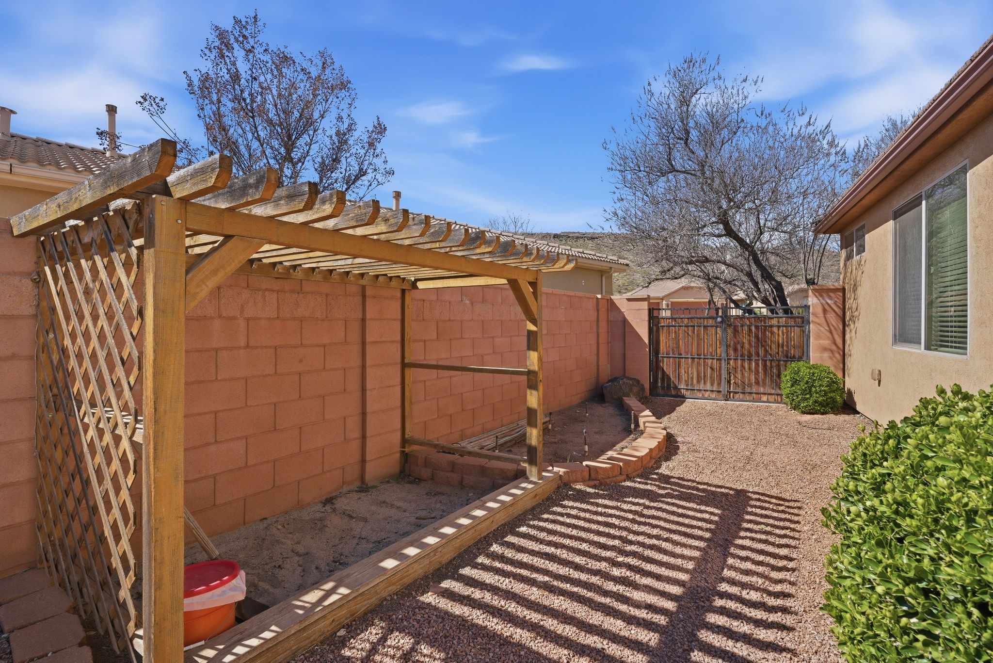 Fenced backyard featuring a gate and a pergola