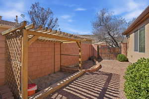 Fenced backyard featuring a gate and a pergola