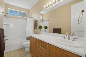 Bathroom with vanity, shower / bathtub combination with curtain, and light tile patterned floors