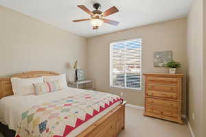 Bedroom with light colored carpet and ceiling fan
