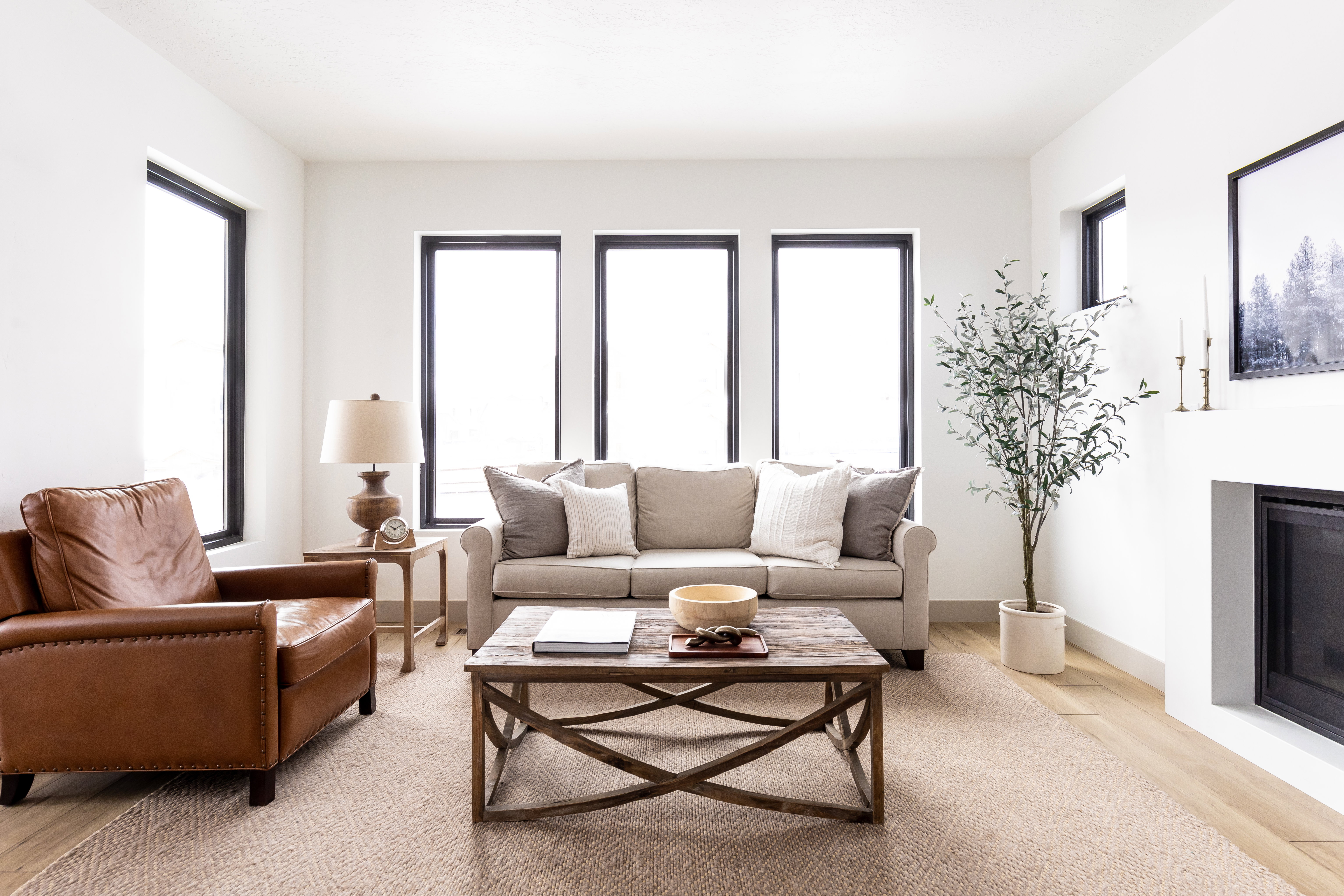 Living room with light wood-style flooring and a glass covered fireplace