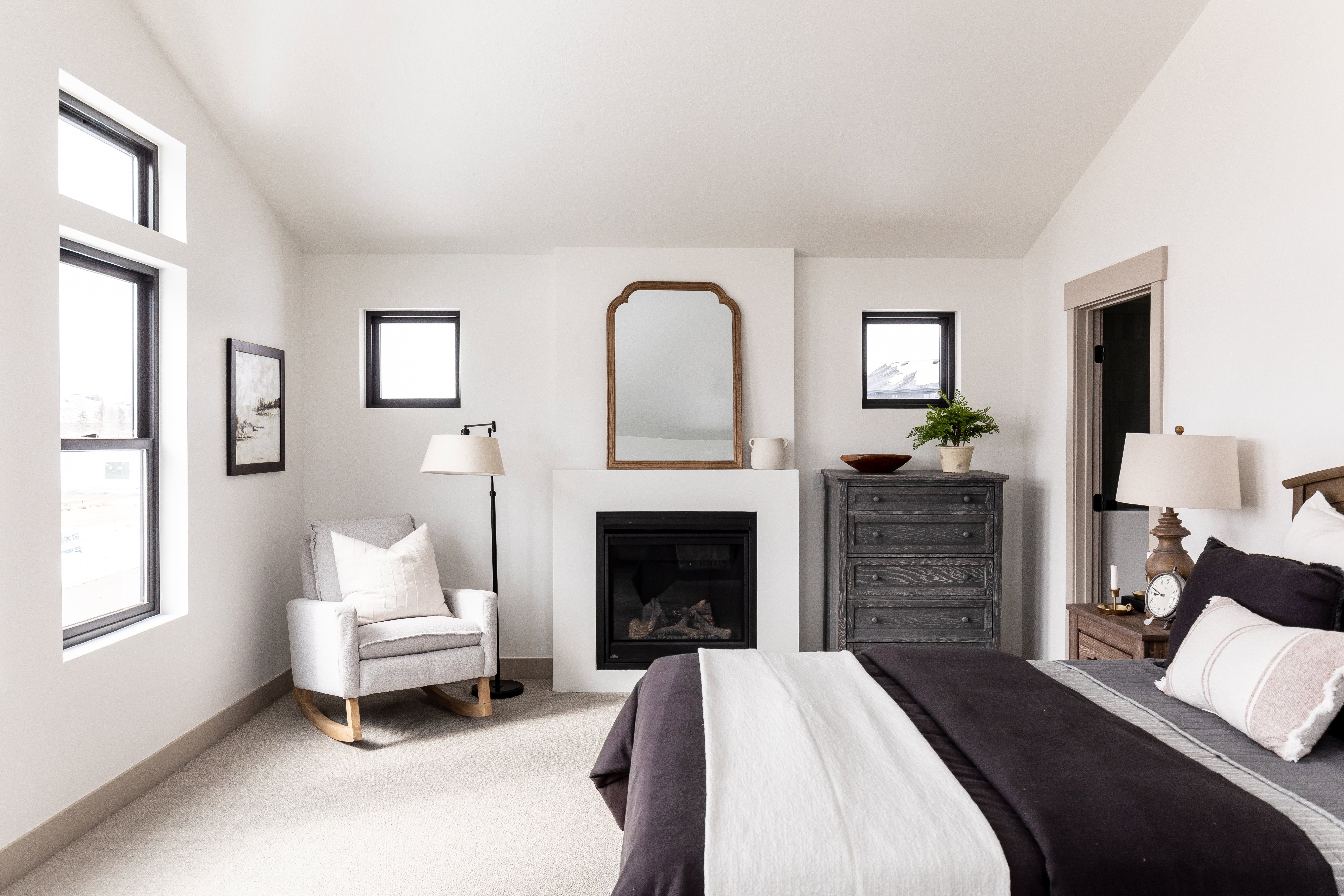 Bedroom with lofted ceiling, a glass covered fireplace, and carpet floors