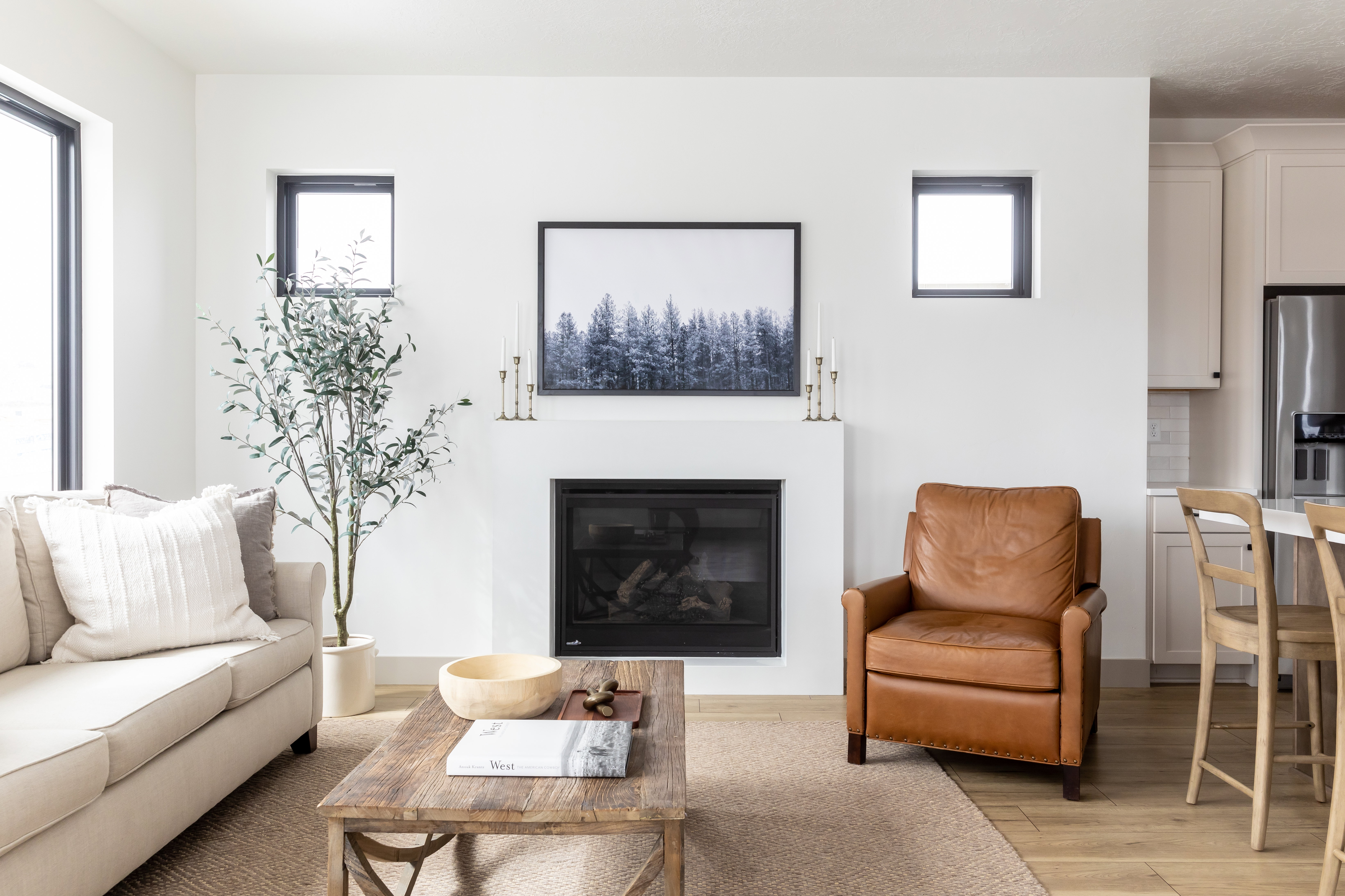 Living room featuring a glass covered fireplace, light wood-style flooring, and plenty of natural light
