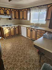 Kitchen with white appliances, light countertops, and wood finish cabinetry