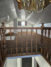 Mudroom featuring a textured ceiling, carpet flooring, and suspended lighting