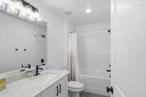 Full bath featuring vanity and shower / bath combo with shower curtain