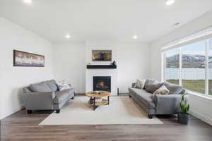 Living area featuring a mountain view, wood finished floors, a fireplace, and recessed lighting