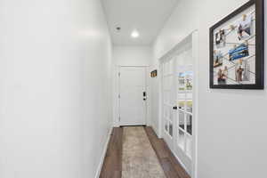 Doorway to outside featuring wood finished floors and baseboards