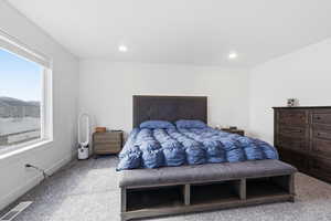 Bedroom with light colored carpet and baseboards