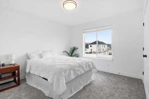 Bedroom featuring carpet and baseboards