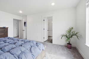 Carpeted bedroom featuring ensuite bathroom and recessed lighting