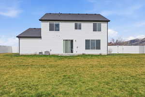 Rear view of property featuring a fenced backyard, a mountain view, a patio, and a shingled roof