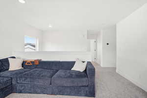 Living room with light carpet and recessed lighting