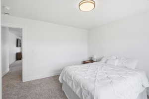 Bedroom featuring carpet flooring and baseboards