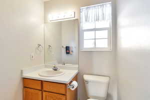 Half bathroom with vanity and toilet