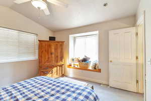 Bedroom featuring carpet flooring, lofted ceiling, and ceiling fan