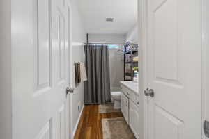 Bathroom with vanity, dark wood-style flooring, and shower / bath combo