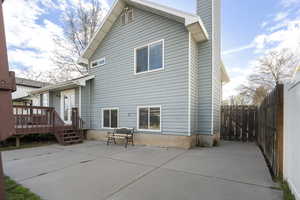 Back of property featuring a patio area, a chimney, and a wooden deck