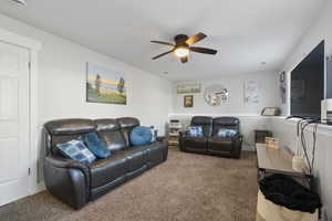 Living room featuring carpet floors and ceiling fan