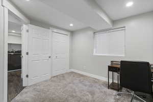 Home office with light carpet and recessed lighting