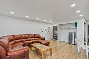 Living room with light wood-style floors and recessed lighting