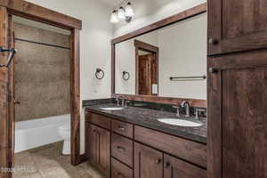 Full bath featuring double vanity and bathtub / shower combination