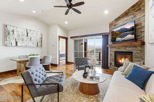 Living area featuring ceiling fan, light wood-style flooring, a fireplace, recessed lighting, and vaulted ceiling
