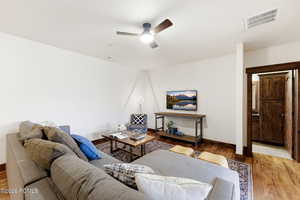 Living room featuring wood-type flooring and ceiling fan