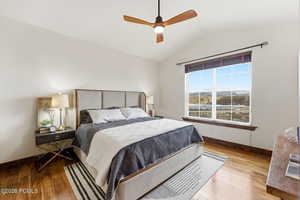 Bedroom with vaulted ceiling, light wood-style flooring, and ceiling fan