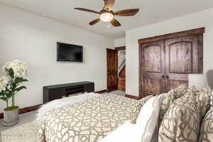 Carpeted bedroom with a closet and a ceiling fan