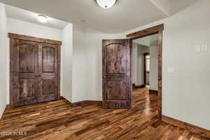 Foyer with dark wood-style floors and baseboards