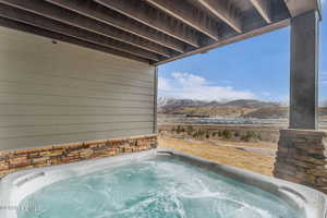 View of swimming pool featuring a hot tub and a mountain view