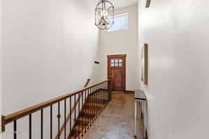 Entrance foyer featuring a high ceiling, stone tile flooring, and hanging lights