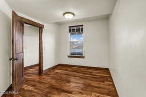 Empty room with dark wood-style flooring and baseboards