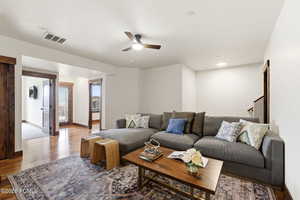 Living room with ceiling fan, wood finished floors, and recessed lighting