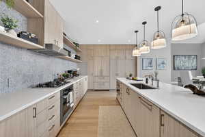 Kitchen featuring open shelves, light wood finish cabinetry, light wood-style floors, modern cabinets, and light stone counters