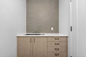 Bathroom featuring vanity and decorative backsplash