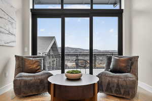 Sitting room featuring a mountain view, light wood-type flooring, and floor to ceiling windows