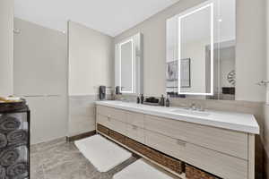 Bathroom featuring double vanity and tile walls