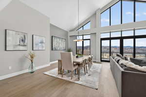 Dining area with light wood-style floors, vaulted ceiling, and a mountain view