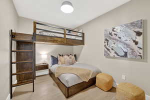 A stylish bunkroom with a full bed below and twin bunk above