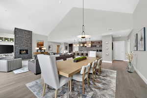 Dining space with a fireplace, vaulted ceiling, and light wood-type flooring