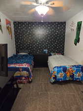 Bedroom featuring ceiling fan and dark colored carpet