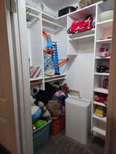 Walk in closet with dark colored carpet