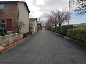 View of asphalt road featuring curbs and a residential view