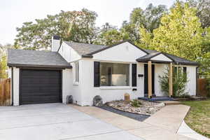 View of front of house with brick siding, roof with shingles, concrete driveway, and an attached garage